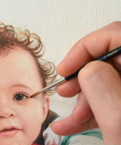 Main d’artiste peignant un portrait de bébé à l’huile