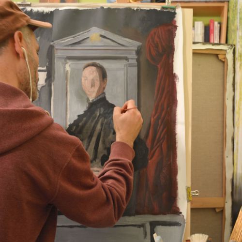 Artiste portraitiste peignant une toile dans son atelier